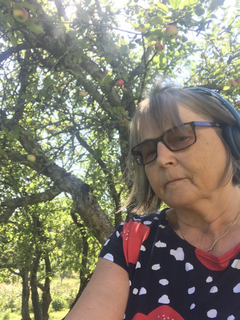 Leena Vainio kesäisen omenapuun varjossa