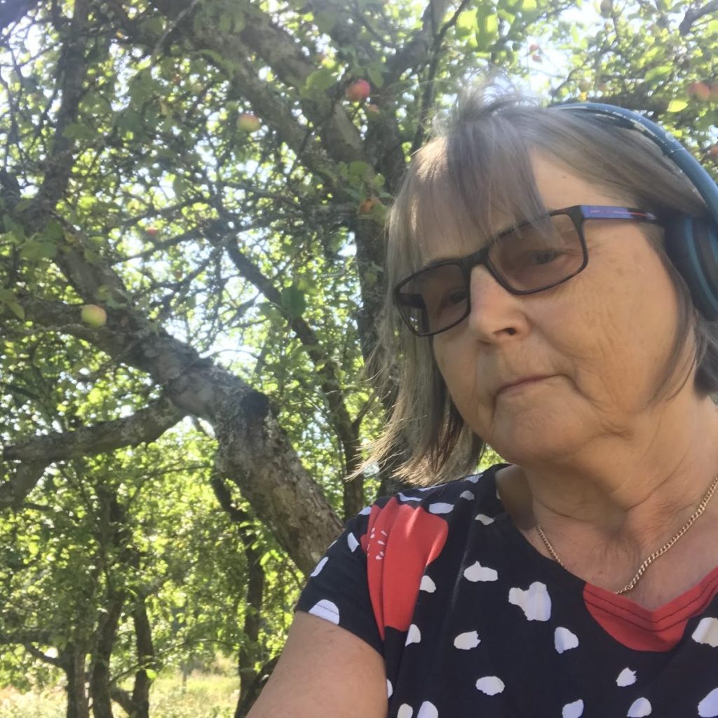 Leena Vainio kesäisen omenapuun varjossa